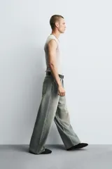 Jeans de denim de algodón, color azul oscuro con efecto lavado. Presentan un corte muy holgado (baggy fit) en toda la pierna y tiro medio. Tienen cinco bolsillos y cierre frontal con cremallera y botón.