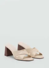 Sandalia de tacón bloque color beige, con diseño de tiras cruzadas en el empeine y puntera abierta.
