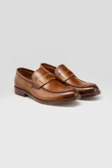 Mocasines de cuero color marrón con diseño tradicional tipo antifaz y costuras visibles en el empeine.