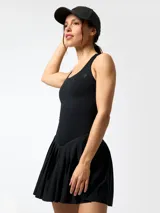 Vestido corto deportivo negro con falda plisada y short interior integrado, de tirantes anchos y cuello redondo.
