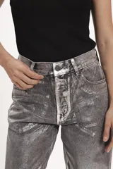 Pantalón de jean corte regular con acabado metalizado plateado, diseño de cinco bolsillos y cierre frontal con botón y cremallera.