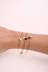 Pulsera de cadena dorada con dijes de piedras naturales y cuentas de colores. Presenta un diseño delicado con eslabones finos y cierre de mosquetón.