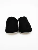 Pantuflas cerradas de pana negra con interior de corderito sintético color crema.