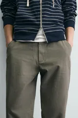 Pantalón de corte carrot fit confeccionado en tejido de algodón con estructura diagonal y efecto lavado. Presenta bolsillos frontales con bolsillo cerillero, bolsillos traseros de plastrón y cierre frontal con cremallera y botón.