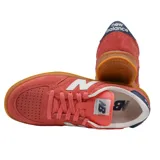 Championes New Balance modelo 500, color rosado con detalles en blanco y suela de goma color caramelo. Presenta el logo característico en los laterales y refuerzo en el talón en color azul marino.