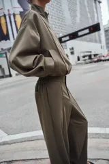Pantalón de tiro alto con pernera recta, cintura elástica en la parte posterior y nervio marcado en el frente. Cuenta con cierre frontal de botón y ganchos, bolsillos delanteros y bolsillos de plastrón en la parte trasera.