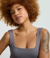 Vestido largo tipo midi de corte ajustado, confeccionado en poliamida con elastano. Presenta escote cuadrado, breteles anchos y una abertura lateral en el ruedo.