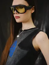 Musculosa entallada de tejido de punto con efecto lavado en tonos negro y gris, sin mangas y corte al cuerpo. Cuenta con un diseño de recortes estructurados y un estampado frontal en azul.