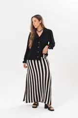 Camisa de manga larga color negro, con cuello camisero, cierre frontal con botones y detalle de volados en la cartera y los puños.