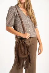 Blusa de algodón con estampado de cuadros vichy en tonos negro y blanco. Presenta escote en V, cierre frontal con botones y mangas cortas abullonadas con terminación elástica.