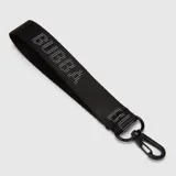 Billetera rectangular de diseño acolchado con textura arrugada, color negro. Cuenta con una correa de muñeca extraíble, cierre perimetral y parche frontal con el logo de la marca en color verde lima.