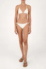 Top de bikini triangular color crema con cordones finos para anudar al cuello y espalda, decorado con bordados de cuentas en relieve sobre las copas.