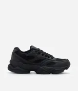 Championes estilo dad sneaker de diseño robusto, color negro, con suela alta y recortes laterales. Presentan cierre mediante cordones y una estructura que combina paneles de malla y material sintético.