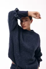 Sweater de tejido de punto con silueta relajada, cuello redondo y mangas tres cuartos con volumen abuchado.