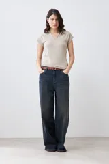 Remera de punto canalé color beige melange, con cuello polo y mangas cortas.