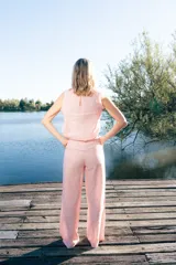 Pantalón de lino de corte sastrero, tiro medio y pierna recta con pinzas. Diseño a rayas blancas y rojas, con bolsillos laterales y botón frontal efecto madera.