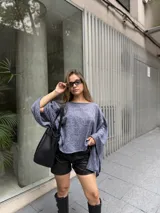 Poncho de hilo liviano en color azul jaspeado, con diseño sin cuello y caída fluida asimétrica.