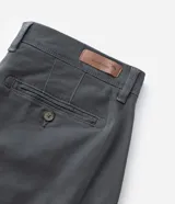 Bermuda masculina slim confeccionada en sarga de algodón con elastano, color beige, con bolsillos laterales tipo chino, bolsillos traseros embutidos con botón, trabillas en la cintura y cierre frontal con botón y cremallera.