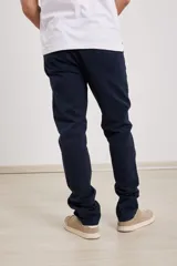 Pantalón chino de hombre color verde oscuro, corte slim, confeccionado en algodón con elastano, con triple pespunte en las costuras y botones al tono.