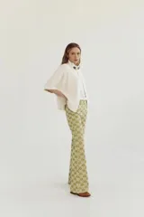 Pantalón de corte acampanado con diseño estampado en tonos verdes y amarillos.