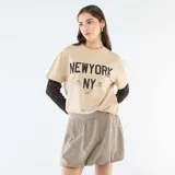 Falda corta estilo globo con estampado de cuadros pequeños en tonos beige y marrón. Presenta una cintura elástica cómoda y un corte voluminoso característico del diseño tipo globo.