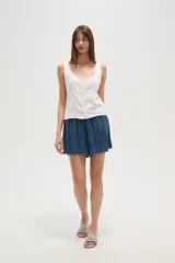 Musculosa blanca de viscosa con escote redondo, cierre frontal con botones y detalles bordados en los hombros.