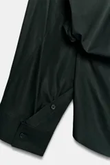 Camisa oversize de popelín de algodón, color verde oscuro, con cuello solapa, manga larga con puños abotonados y cierre frontal con botones.