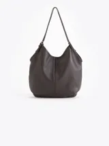 Bolso tipo hobo confeccionado en cuero vacuno negro con efecto rugoso y acabado suave. Presenta manijas finas para llevar al hombro, costura central vertical y un pequeño llavero de cuero colgante con el logo de la marca.