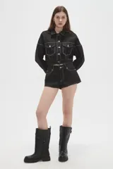 Short de jean negro engomado, de tiro medio y corte ajustado, con bolsillos laterales y traseros y costuras pespunteadas en contraste.