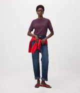 Blusa de manga corta confeccionada en algodón pima con cuello redondo y diseño liso, de corte recto con bajo ligeramente más extendido en la parte delantera.