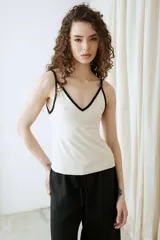 Top de algodón color crudo con tirantes y ribetes en contraste de color negro, escote en V y diseño al cuerpo.