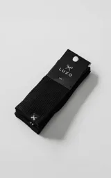 Pack de dos pares de medias de algodón con textura acanalada, color negro. Presentan una etiqueta pequeña con el logo de tijeras en el borde superior.