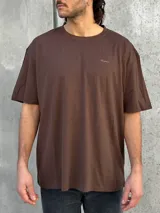 Remera marrón de corte amplio con estampado en la espalda con la palabra 'Perception' y otras frases en color dorado.