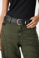 Cinturón de cuero negro con costuras decorativas, hebilla metálica plateada y pasador con detalle de marca grabado.