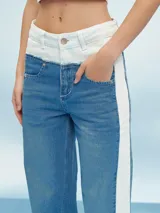 Pantalón de jean azul con cintura clara y una franja blanca vertical en los laterales.