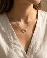 Collar de plata 925 con dije de Minnie Mouse, compuesto por un círculo plateado y un lazo con baño de oro rosa.