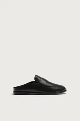 Mocasines destalonados de cuero color negro, de diseño liso con detalle de antifaz en el empeine y horma redonda.