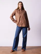 Camisa color verde oliva de lyocell, marca Cyrus. Tiene cuello con solapa, abertura central con botones, mangas 3/4 regulables con presilla y botón, y dos bolsillos delanteros aplicados.