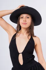 Vestido corto negro de encaje con escote halter, abertura en el pecho y falda de volantes.