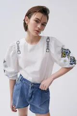 Short de jean azul de calce holgado, tiro alto, piernas anchas con tablas y ruedo desflecado.