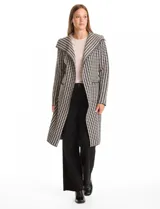 Chaqueta larga de tejido de punto con estampado de pata de gallo en blanco y negro. Presenta cuello de solapa, cierre frontal con lazo ajustable en la cintura y bolsillos aplicados en el frente.