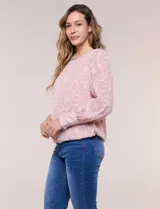 Blusa blanca de organza con textura devoré floral, silueta semiholgada y forro interno. Tiene escote bote, mangas largas abullonadas con transparencias, puños anchos con botones y ruedo elastizado.