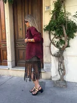 Camisa de denim color borgoña con efecto lavado, corte holgado, cuello clásico y cierre frontal con botones dorados.