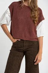 Chaleco sin mangas de tejido de punto color rosado pálido, con textura calada y acabado lurex, corte al cuerpo y cuello redondo.