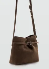Bolso de mano tipo bandolera confeccionado en piel bovina de color marrón. Cuenta con un diseño estructurado, solapa frontal con detalle de trabilla y hebilla metálica, y asa corta para llevar al hombro o en la mano.
