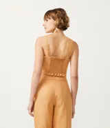 Blusa musculosa corta color ocre, con escote cuadrado, tirantes anchos elásticos, pliegues delanteros y lastex en la espalda.