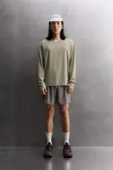 Camiseta de entrenamiento regular fit color gris oscuro, confeccionada en tejido técnico ligero y elástico con estructura. Cuenta con cuello redondo, manga larga y logo estampado en el bajo.