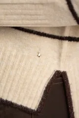 Sweater de punto con diseño de rayas horizontales en tonos neutros, cuello redondo, manga larga y puños acanalados.