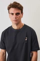 Remera blanca de manga corta y corte holgado, con cuello redondo y pequeño estampado en el pecho.