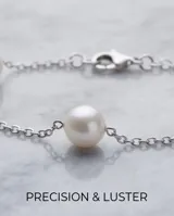 Pulsera de cadena de plata con perlas espaciadas a lo largo de su diseño.